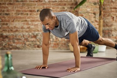 Young Male Athlete Practicing Push-Ups At Home