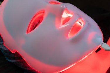 a woman wearing an LED mask, as a natural remedy for acne scars