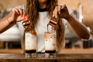 Woman pours coffee, a sweat-inducing food, from cups into glasses