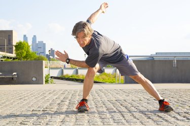 Caucasian man stretching in urban park