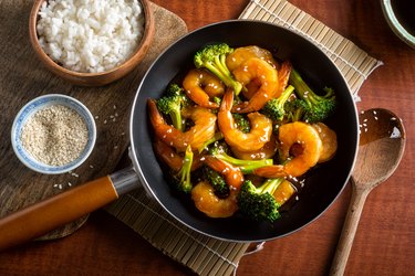 Shrimp and broccoli in pan with white rice on the side