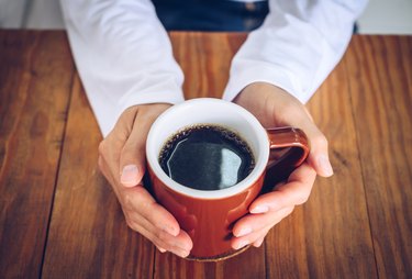 Person holding a heart-healthy cup of coffee