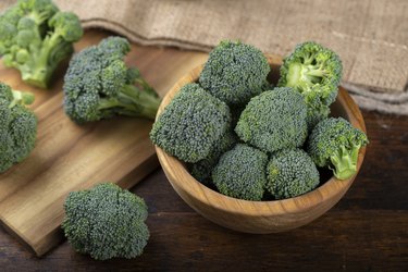 Fresh broccoli with in bowl on wooden table close up.