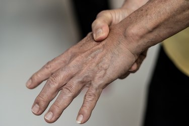 Close up of person clutching tingling hand to show what happens when a man ph balance is off and men/male ph balance off symptoms