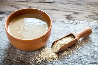 Healthy fat-rich tahini in bowl with sesame seeds