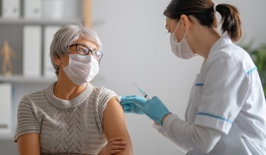 Doctor giving a woman a COVID-19 vaccine