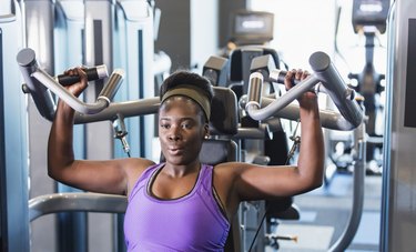 Person wearing purple tank top working out at the gym