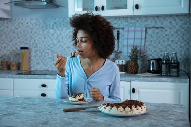Person Eating A Piece Of sugary chocolate Cake, one of the worst foods for sleep health