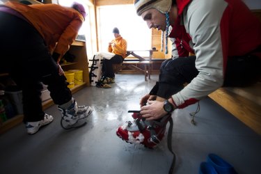 People adjusting ski boots indoors