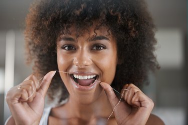 A woman flossing her teeth