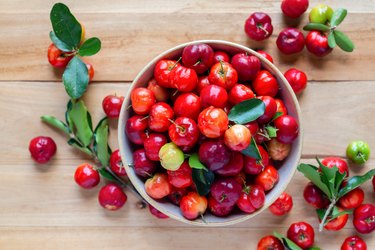 Acerola Cherries in bowl on wooden table