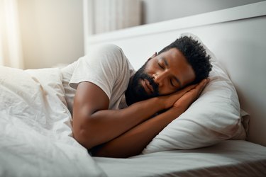 a man in bed sleeping on his side