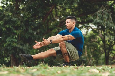 Pistol squat, man doing body-weight workouts outdoors
