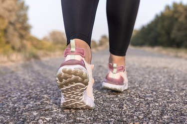 Close shot of person wearing running shoes and walking on pavement as a visceral fat real image of what fat looks like inside body