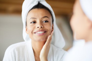 woman moisturizing her face after a shower, as a natural remedy for eczema