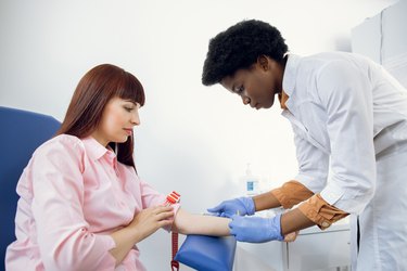 lab technician taking blood for phospholipid and triglyceride tests