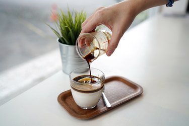 Pouring espresso shot into a glass of yogurt