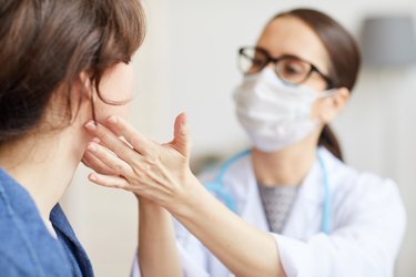 A doctor examining a patient's scalloped tongue