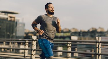 Man going for a run outside across a bridge