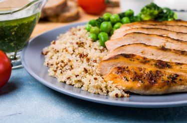 Plate of quinoa, sliced grilled chicken and peas, foods for endurance exercise