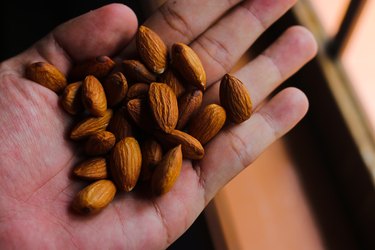 an overhead close up of a hand holding almonds