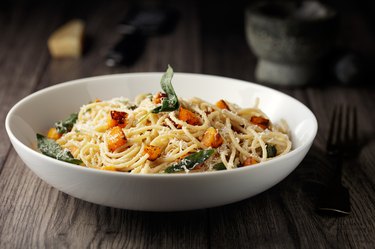 side view of a bowl of spaghetti with roasted butternut squash and sage butter, to represent food with gluten that may cause swelling