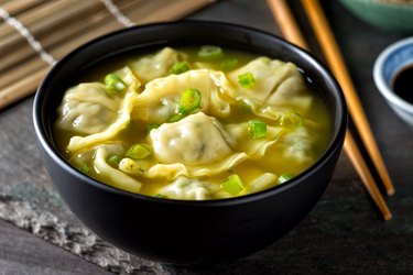 Wonton Soup with Scallions in black bowl on table
