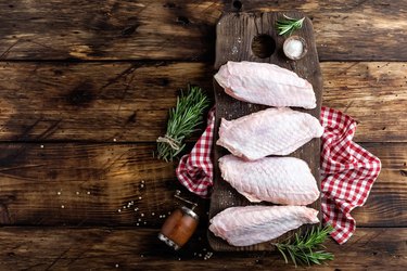 Raw turkey wings on wooden background top view, copy space, flat lay