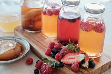 different types of kombucha with fruit in glass jars