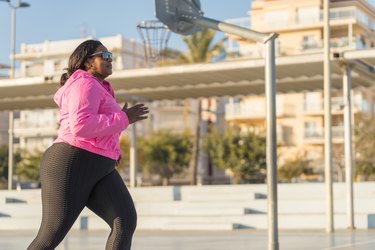 Person in activewear and sunglasses running outside to demonstrate intuitive exercise
