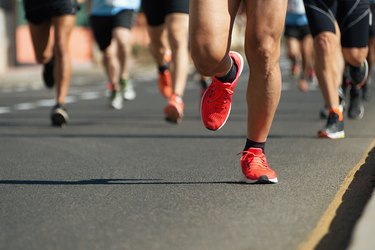 Close-up of people's legs running a race on the street