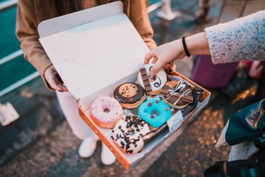 Young woman with a box full of doughnuts