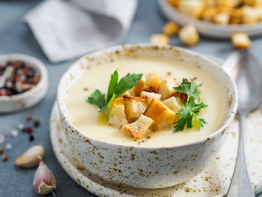 cauliflower soup puree with croutons and parsley in bowl