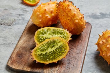 L-citrulline-rich kiwano, or horned melon, sliced and whole on cutting board..