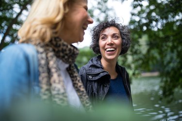 a smiling person with short grey hair on a nature walk with their friend with short blonde hair, as a way to build resilience