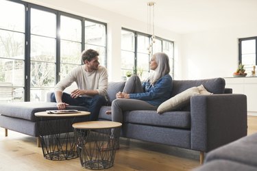 Son sitting on couch, talking to his mother