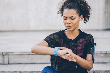 woman checking her smart watch to see why heart rate is high after a workout