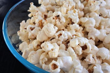 a close-up photo of a blue bowl of popcorn