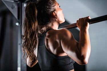 Person doing a pull-up, demonstrating the height recommendation for a pull-up bar.