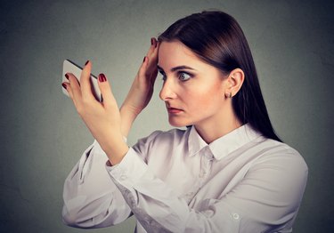 Upset woman surprised she is losing hair has receding hairline. Human emotion.