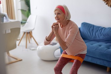 Woman doing resistance band exercises at home.