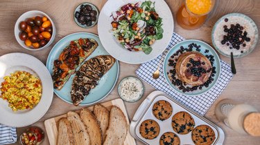 table with high-protein breakfast plates including toast with nut butter pancakes tofu scamble and more