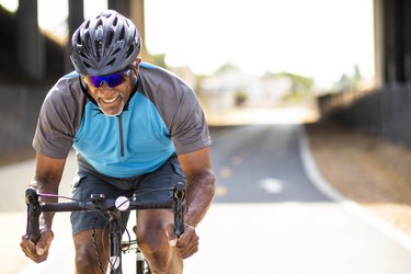 Person riding a bike outdoors after recovering from a hip replacement.