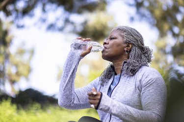 Senior black person drinking water during workout as a method for how to lower electrolytes