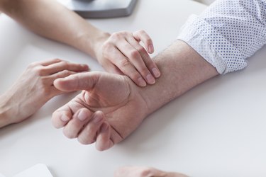 close view of a doctor checking a person's pulse at their wrist