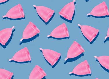pink menstrual cup pattern on blue background conveying concept of getting period twice in a month