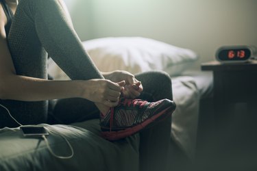A woman lacing up her sneakers for a morning workout, as an example of a weight loss rule to avoid
