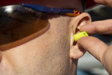 Construction Worker Wearing Protective Ear Plugs to prevent age-related hearing loss