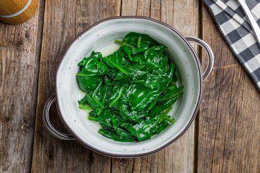 bowl of steamed spinach on wooden table