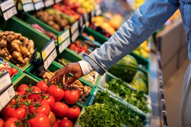 Woman buying fresh vegetables at supermarket